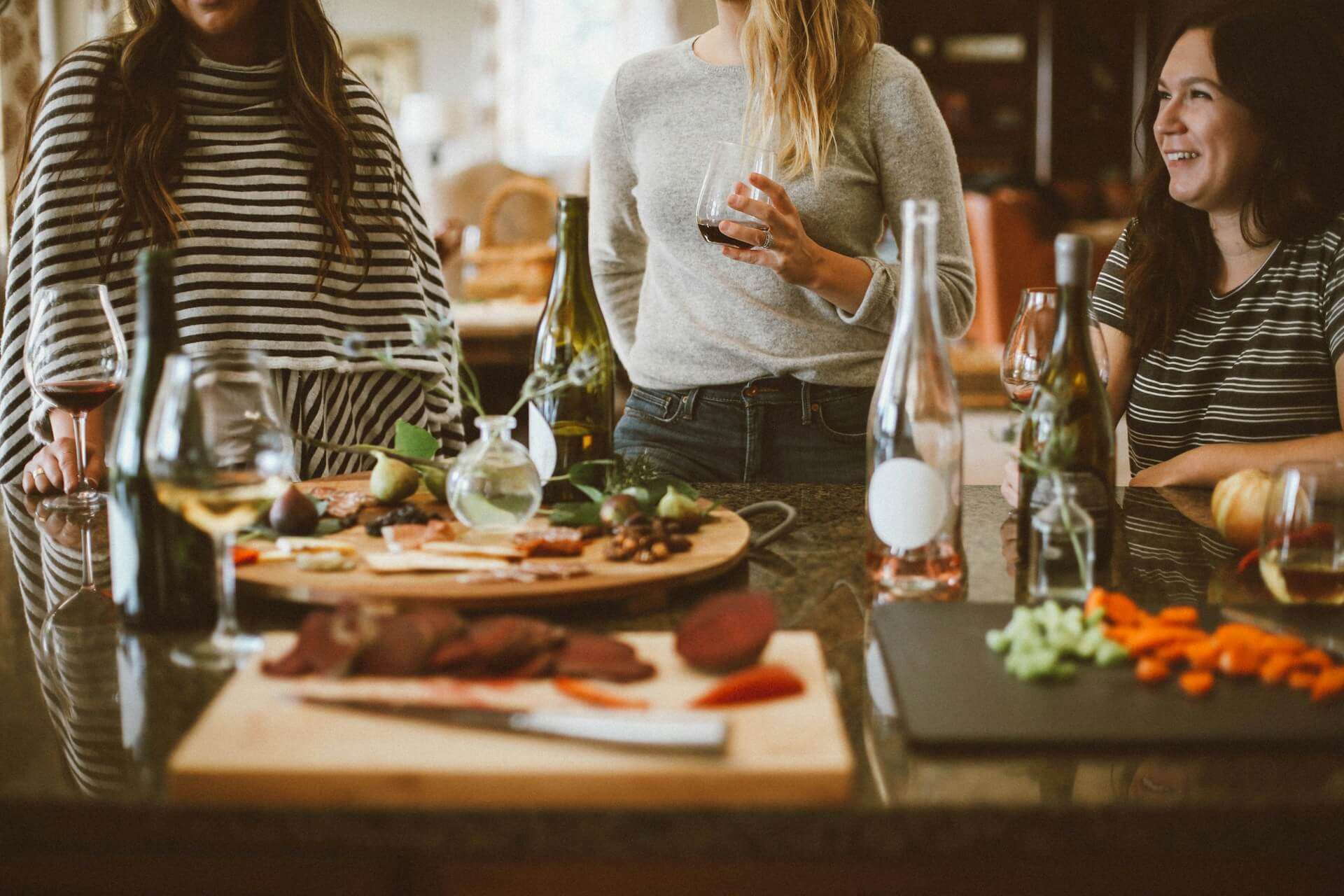 food and drinks on a party table surrounded by people